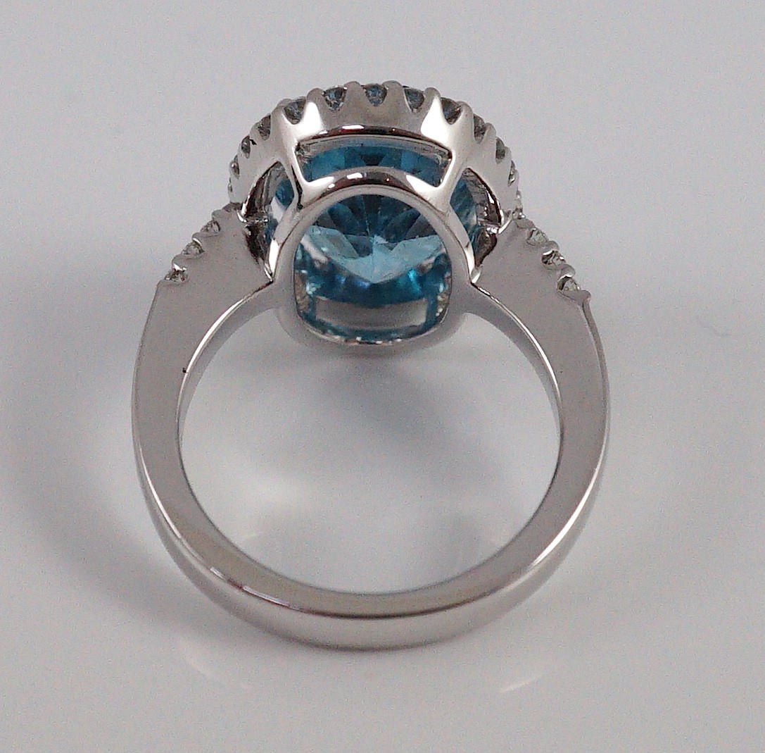 A modern 18k white gold, blue topaz and diamond oval cluster dress ring